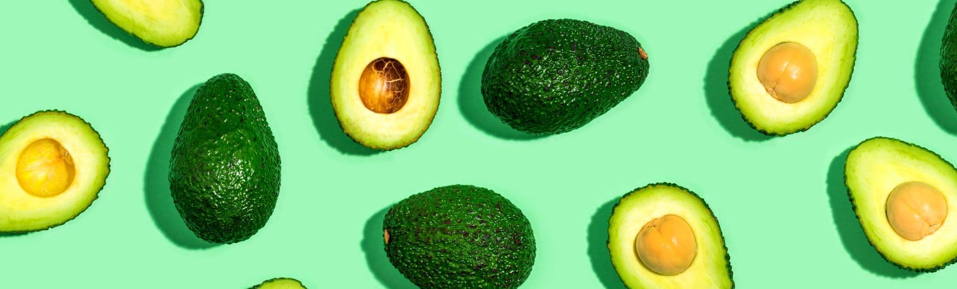 Avocados auf grünem Hintergrund