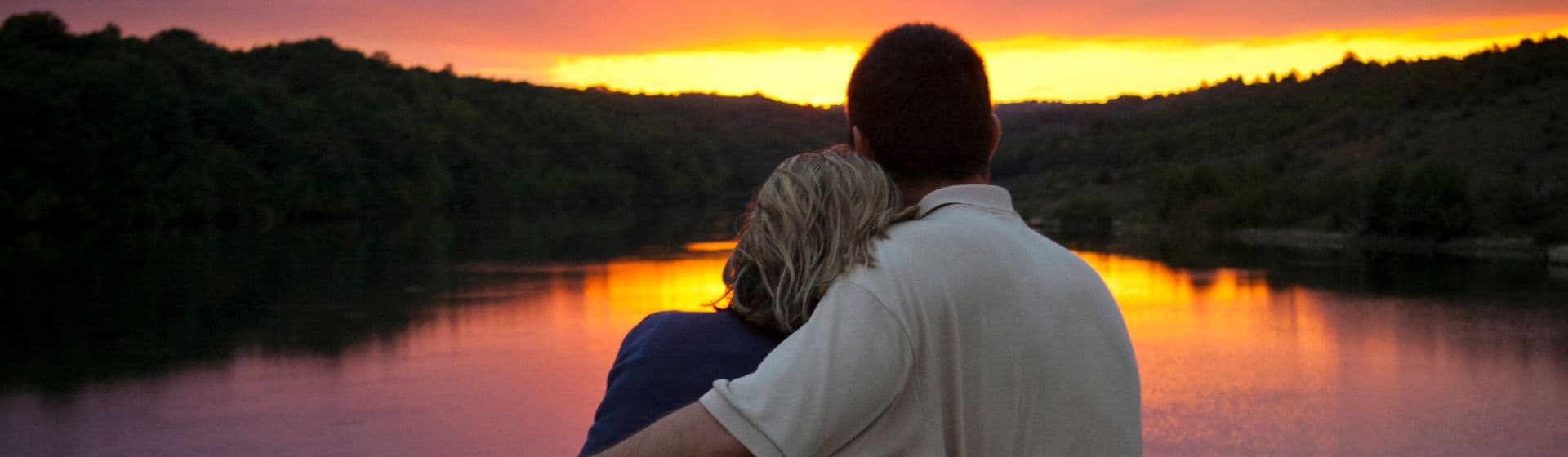 Mann und Frau am See beim Sonnenuntergang